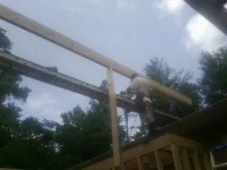 Carpenter setting a ridge beam over a new addition frame — Ice Dam Removal by Roofing Brothers in Medfield