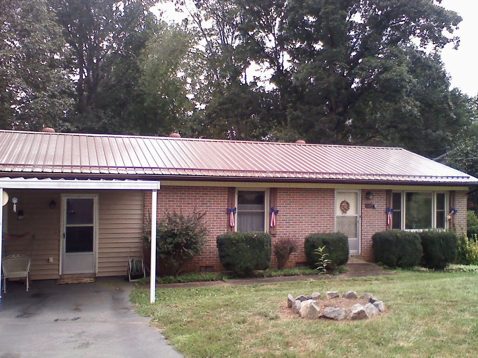 Bronze metal roof and carport on a brick ranch home — Roof Repair work by our crew in Medfield